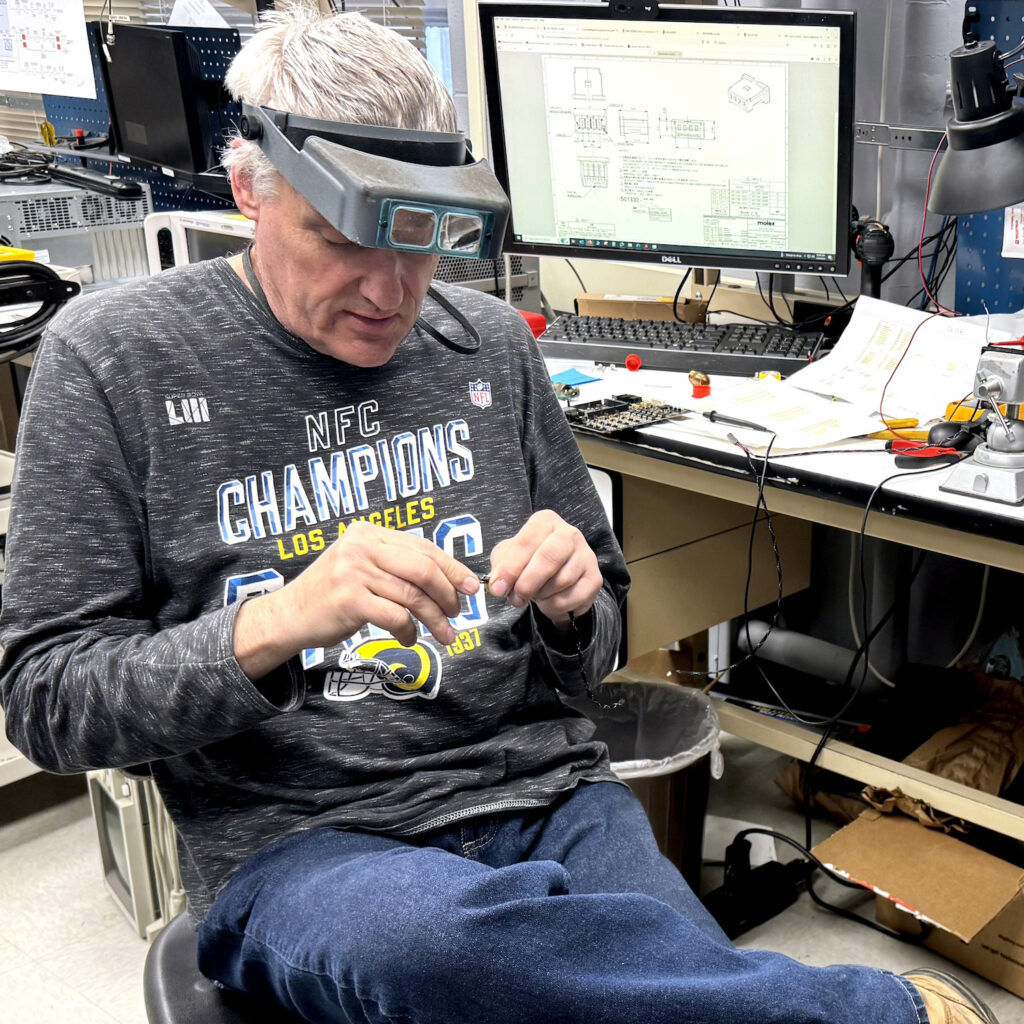 A male technician sitting and working on hardware