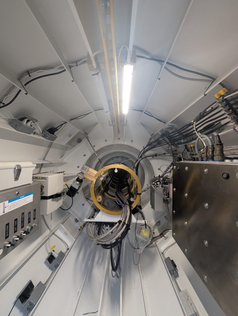 A view into the positioner tube of a radio antenna, with wires coming out of the back and running along the side of the tube