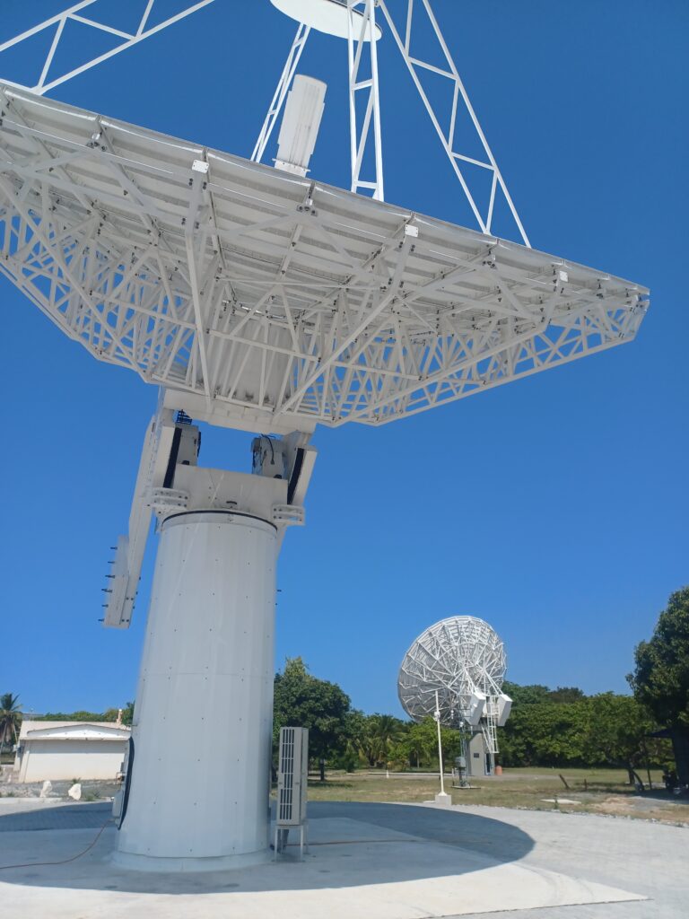 A large white radio antenna against a blue sky